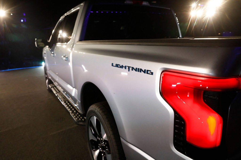 Un primer plano del lado del conductor trasero exterior de una camioneta Ford F-150 Lightning con el logotipo de Lightning visible de forma destacada