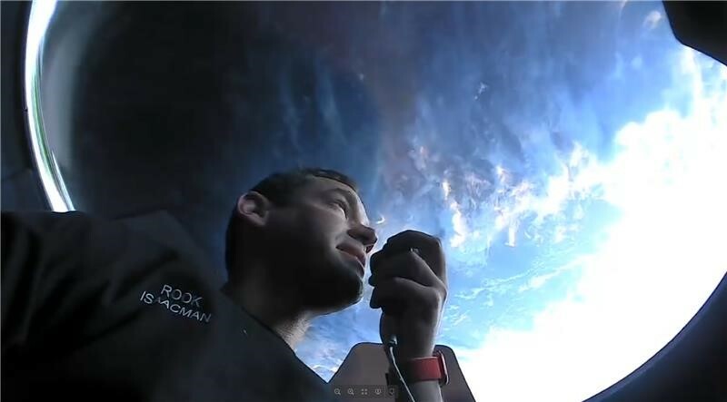 Jared Isaacman mirando a través de la cúpula del Dragón del barco.