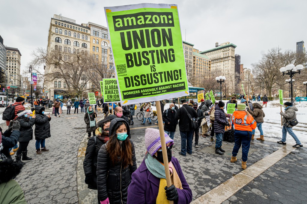 Personas con pancartas contra los esfuerzos antisindicales de Amazon