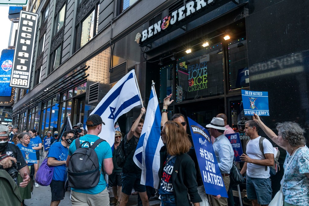 Un grupo de manifestantes ondeando la bandera israelí frente a una tienda Ben & Jerry's.