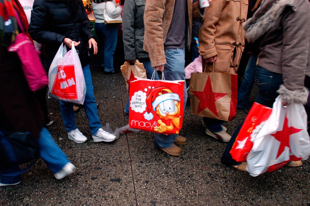 Compradores con bolsas de compras navideñas de Macy's