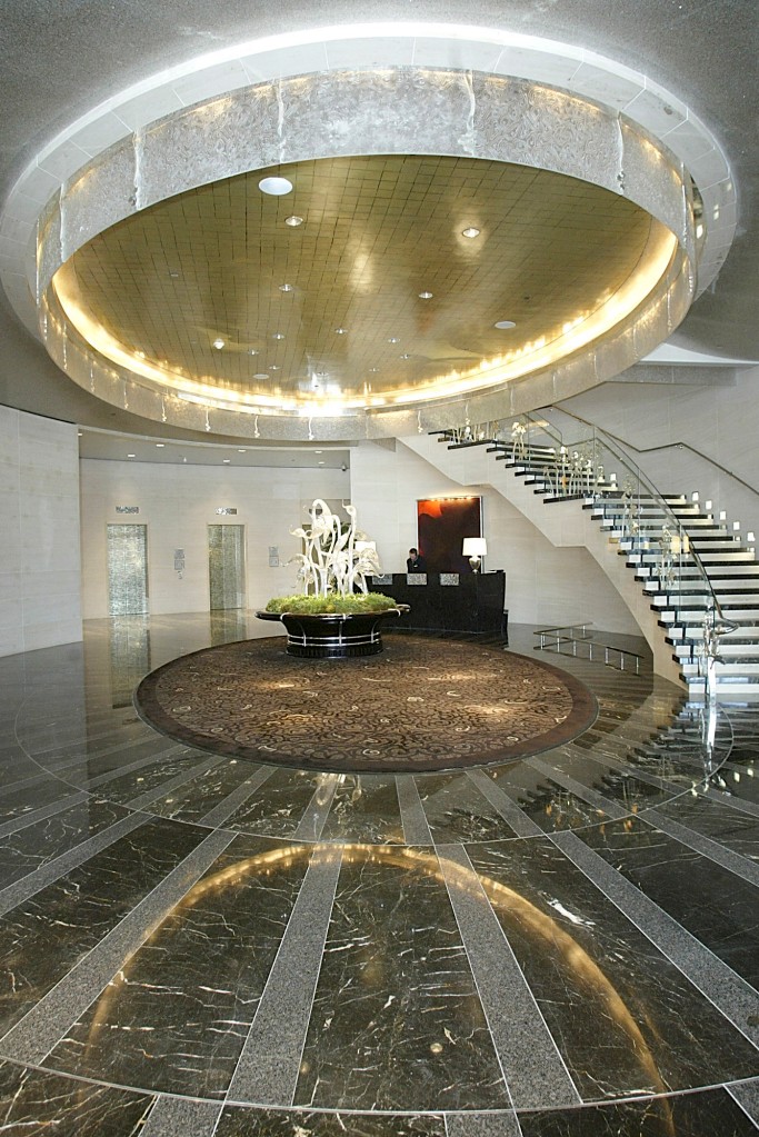 Vestíbulo del Hotel Mandarin Oriental con un techo alto revestido con lámparas de araña y pisos de mármol gris y dorado