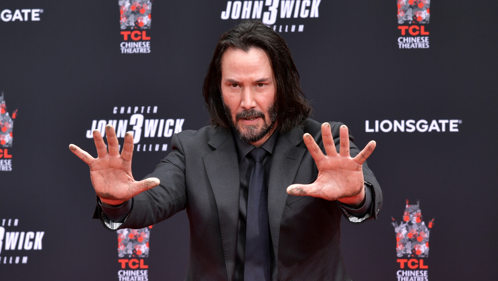 Keanu Reeves en una pose bastante neo en una ceremonia de huellas de manos en la explanada IMAX del Teatro Chino de TCL en 2019.