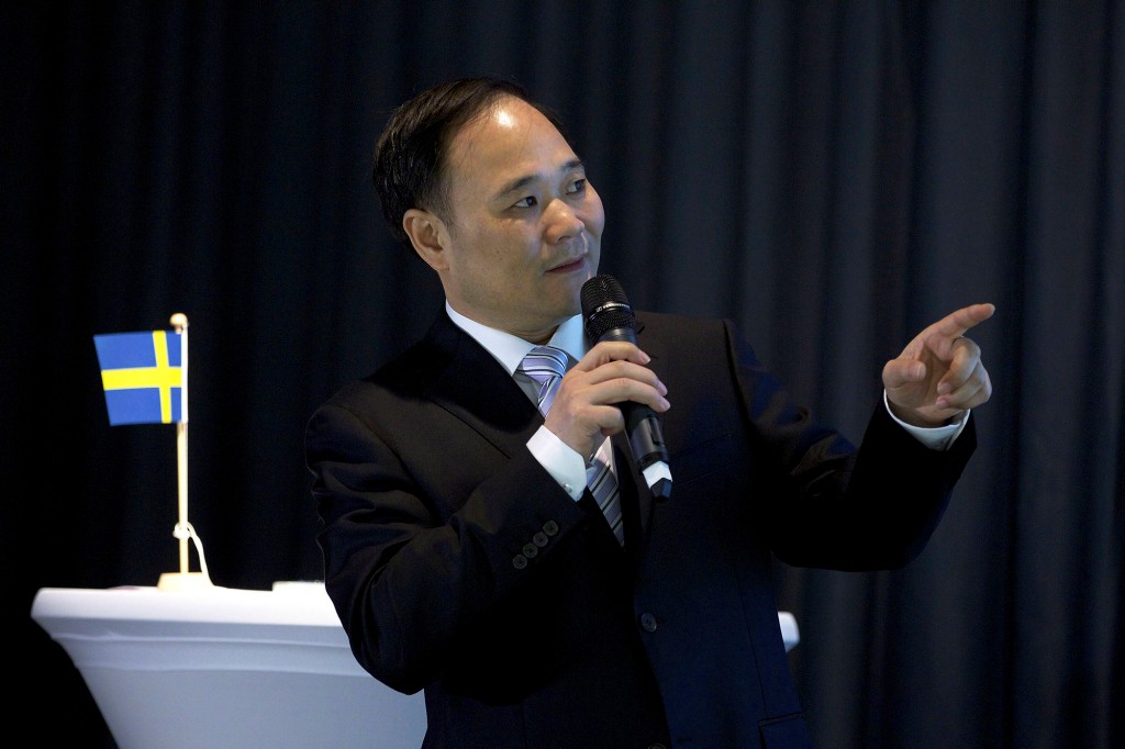 El jefe de Geely, Li Shufu, sostiene un micrófono y habla
