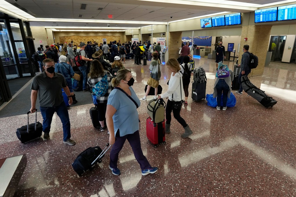 Los pasajeros hacen cola en el mostrador de boletos de Southwest Airlines el domingo 10 de octubre de 2021 en Eppley Airfield en Omaha, Nebraska.