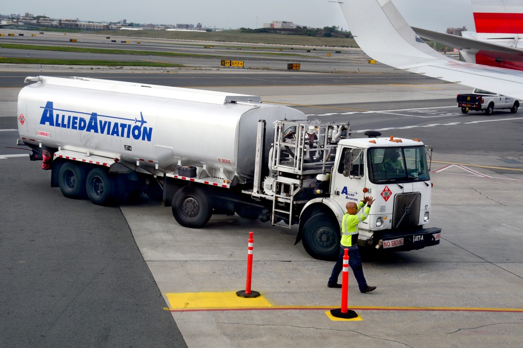 Un camión de combustible para aviones en el asfalto preparándose para alimentar un avión