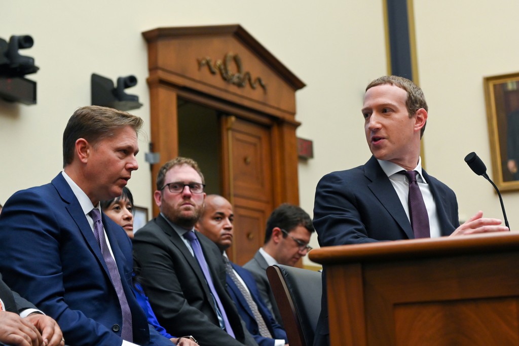 El presidente y director ejecutivo de Facebook, Mark Zuckerberg, consulta con su equipo legal mientras testifica en una audiencia del Comité de Servicios Financieros de la Cámara de Representantes en Washington, EE. UU., 23 de octubre de 2019.