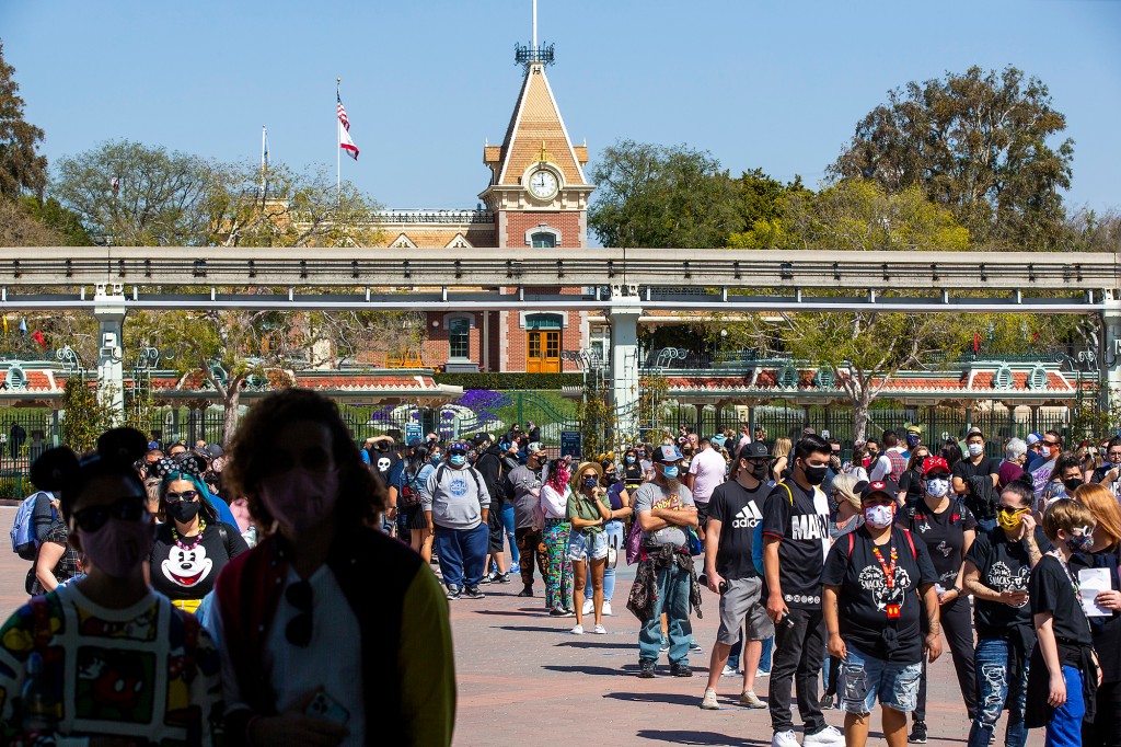   Con una vista de Disneyland detrás de ellos, los fanáticos de Disney hacen fila para asistir al debut de Disney California Adventure. "Un toque de Disney" evento gastronómico en Disney California Adventure Park el jueves 18 de marzo de 2021 en Anaheim, CA. 