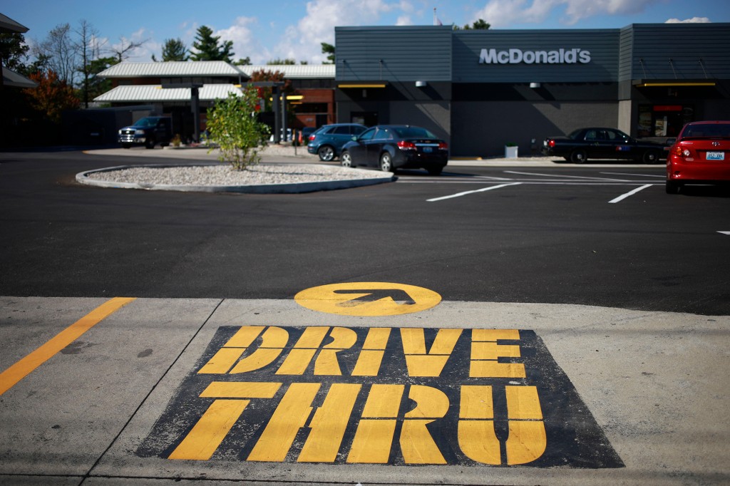 Señal de drive-thru pintada de amarillo en un estacionamiento.