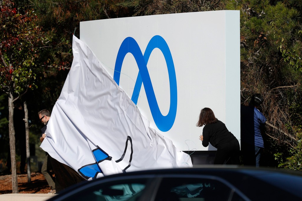 Los empleados de Facebook presentan un nuevo logotipo y el nombre 'Meta' en el letrero frente a la sede de Facebook el 28 de octubre de 2021 en Menlo Park, California.