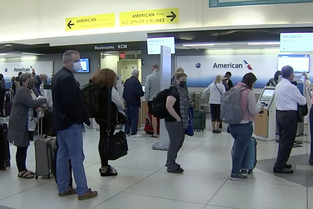 La gente espera en línea en un mostrador de American Airlines en un aeropuerto de Charlotte, Carolina del Norte, el 31 de octubre de 2021 para tomar un vuelo.