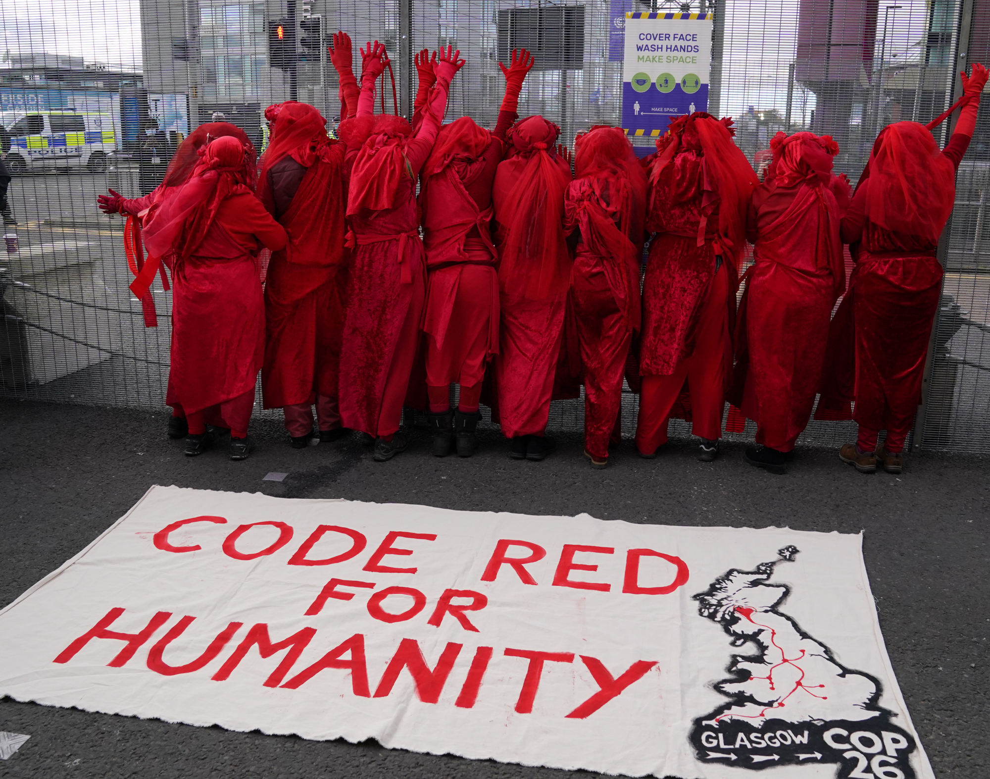 Activistas de la Brigada Rebelde Roja de Extinction Rebellion desfilaron por las estaciones de metro y se quedaron fuera de las reuniones de la COP26, emitiendo una alerta roja climática.