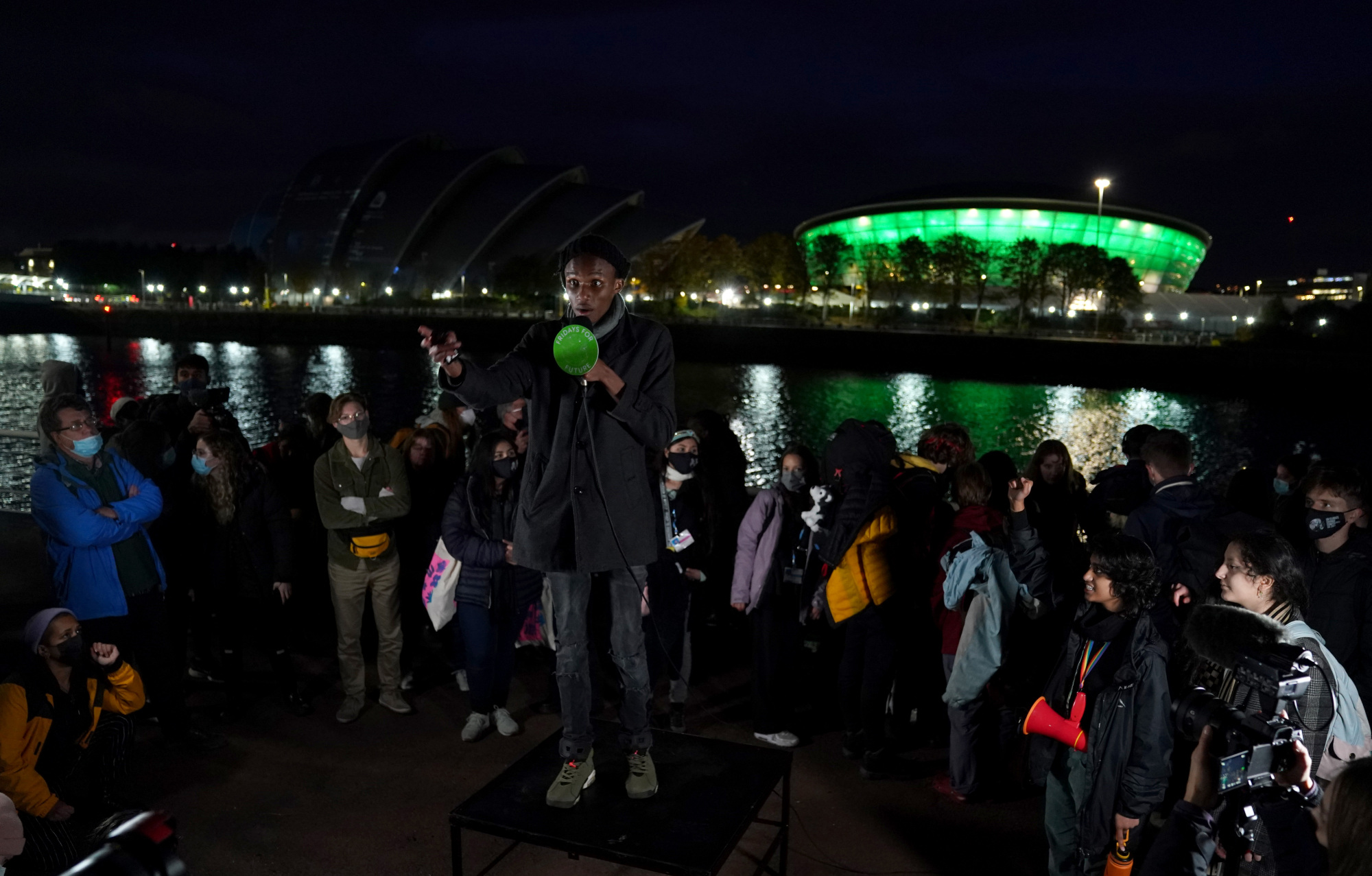 El activista climático de Kenia Eric Ngunga habla a una multitud junto al río Clyde en Glasgow.