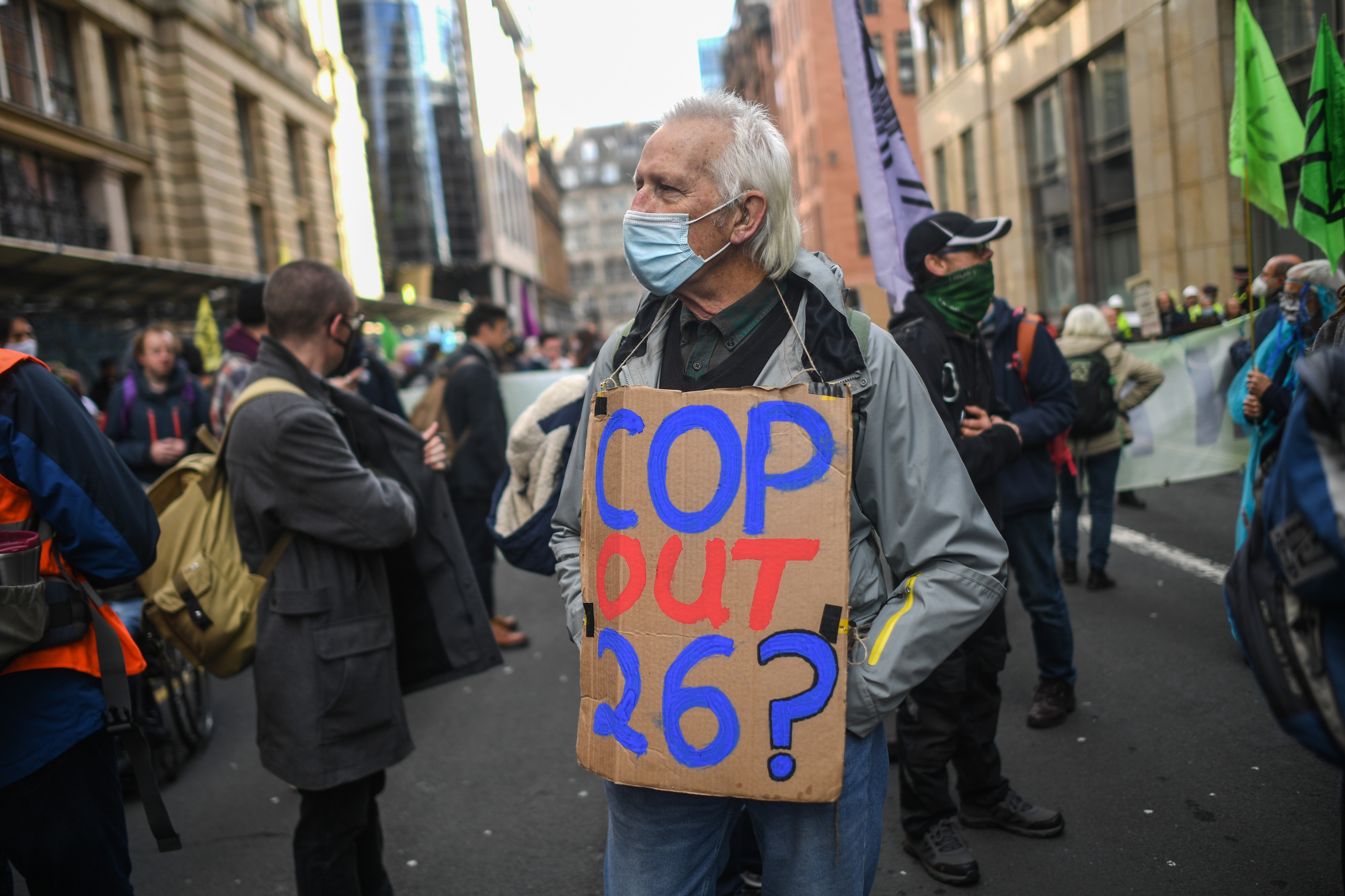 Un manifestante lleva un cartel fuera de la oficina de JP Morgan en Glasgow.