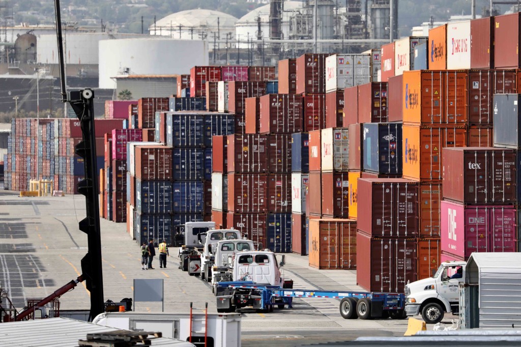 Los camiones esperan para cargar contenedores en el puerto de Los Ángeles, California.
