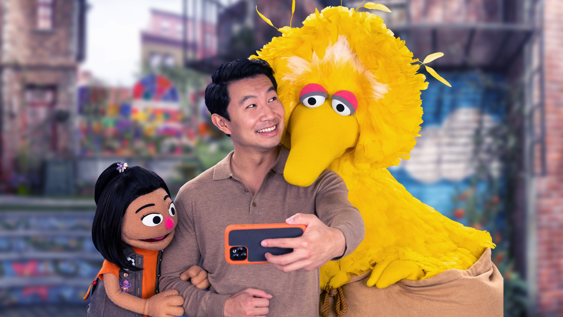 El actor Simu Liu, el muppet Ji-Young y Big Bird se toman una selfie en Barrio Sésamo.