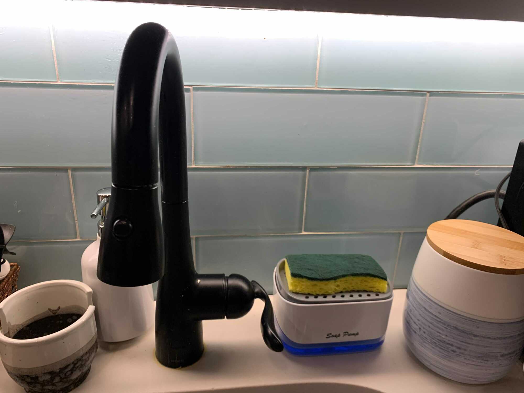 Mi configuración durante esta prueba: un carrito de esponja pequeño vacío, un dispensador de jabón y un carrito dispensador de jabón.  El frasco del extremo derecho contiene mi café, en caso de que sienta curiosidad.