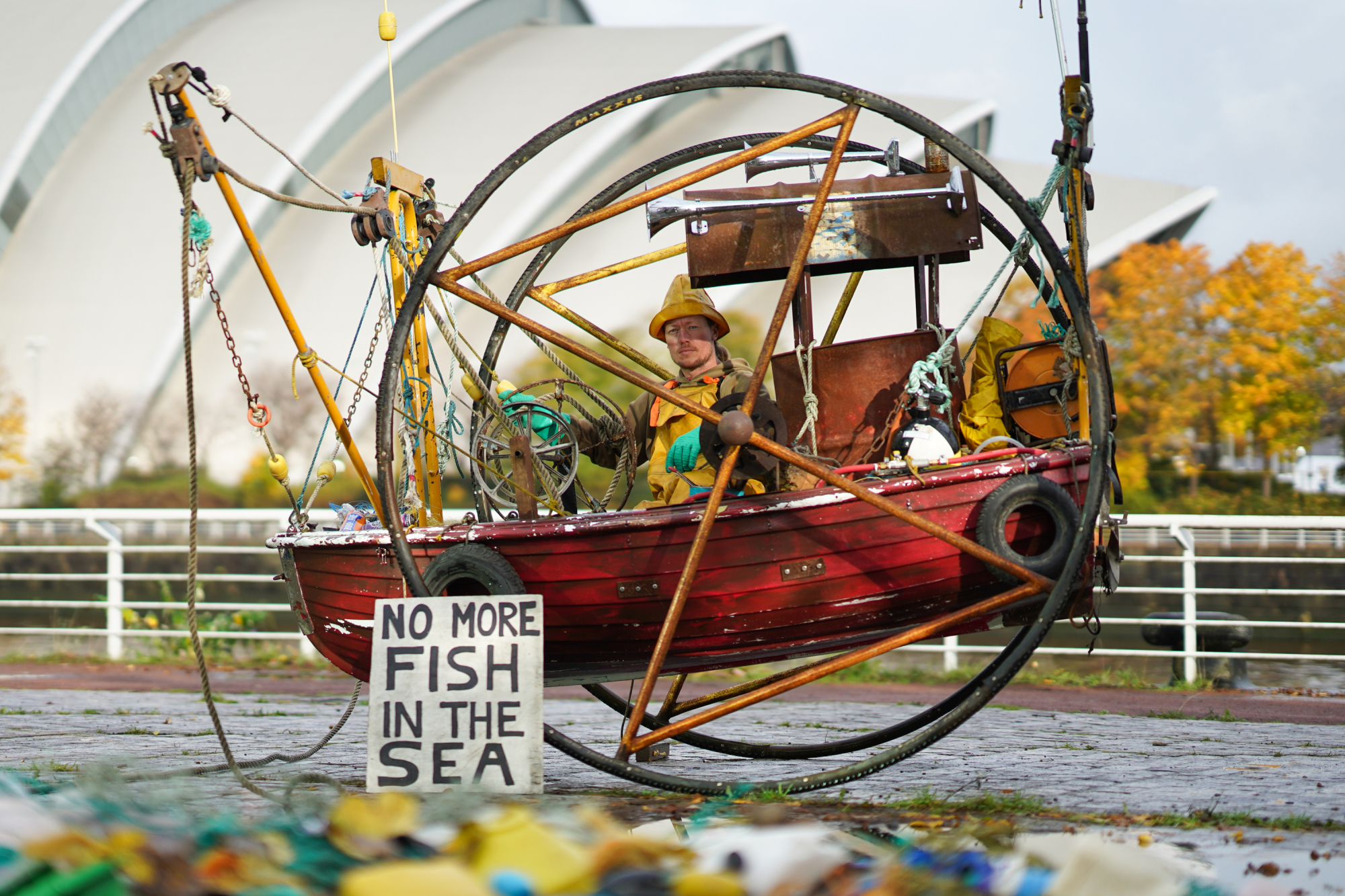 El grupo ecologista Ocean Rebellion monta un barco de pesca recogiendo basura y mer-people muertos fuera de las reuniones de la COP26 en Glasgow, Escocia.