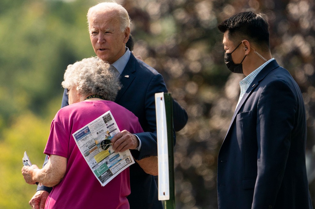 David Cho (derecha) observa cómo el presidente Joe Biden le da un abrazo a una mujer mientras deja St. Joseph en la iglesia católica Brandywine.