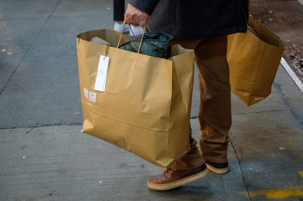 Un primer plano de una bolsa de compras marrón en poder de un consumidor