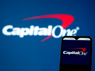 Logotipo de Capital One en el letrero y la pantalla del teléfono inteligente.