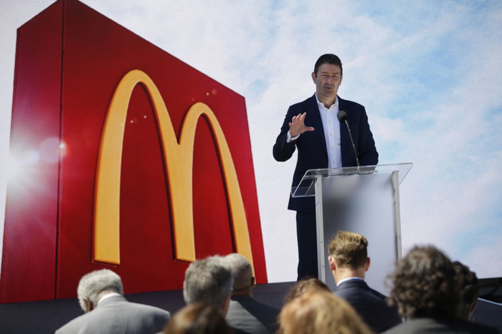 Steve Easterbrook de pie en un podio con un cartel de McDonald's en la parte de atrás.