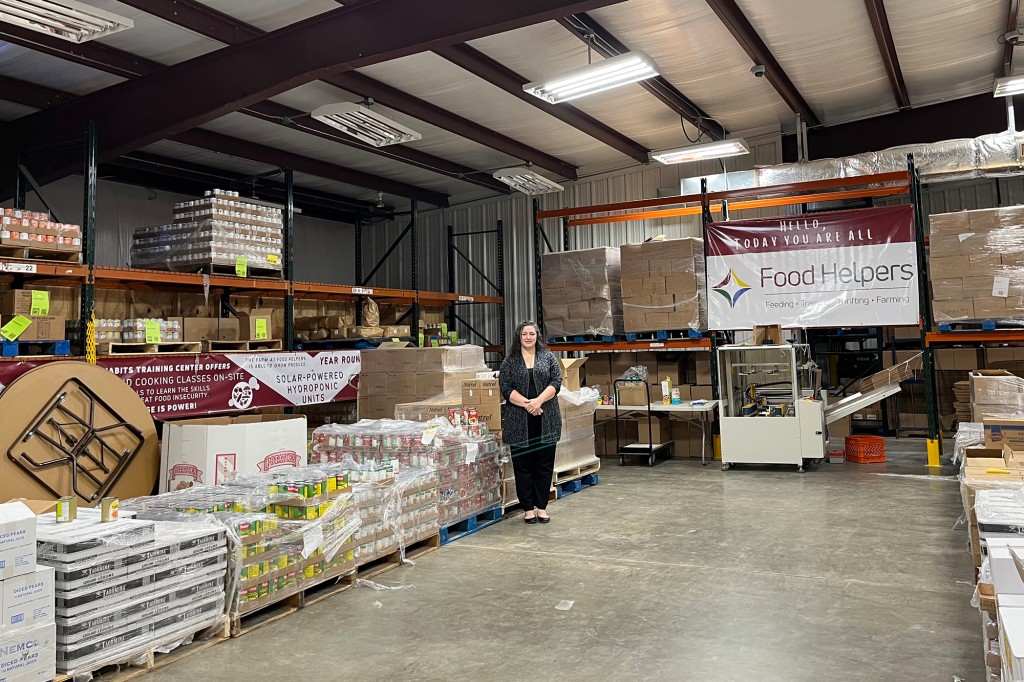 Cherise Sandrock, directora de desarrollo de Food Helpers de pie en el almacén de la organización sin fines de lucro que proporciona bienes a los trabajadores pobres que padecen inseguridad alimentaria y que están profundamente afectados por la inflación porque tienen trabajos para los que no califican a nivel federal y estatal. programa asistente.