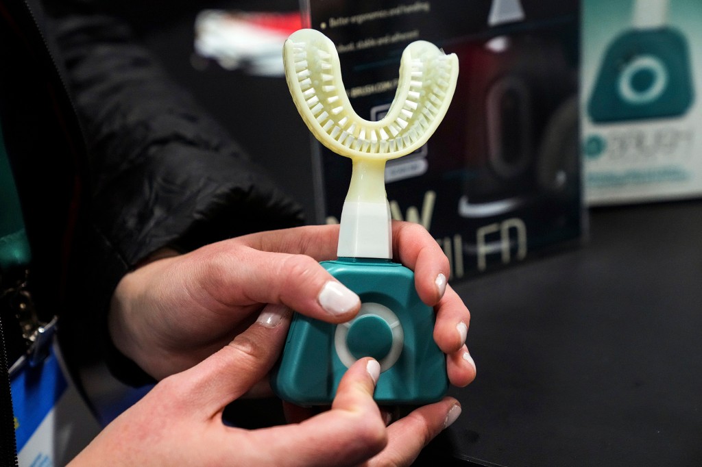 Una mujer sostiene el Fasteesh Y-Brush en el stand de Fasteesh Y-Brush durante el CES presentado antes de la feria tecnológica CES, el lunes 3 de enero de 2022 en Las Vegas.  El cepillo de dientes sónico puede cepillar toda la boca en diez segundos.  (Foto AP / Joe Buglewicz)