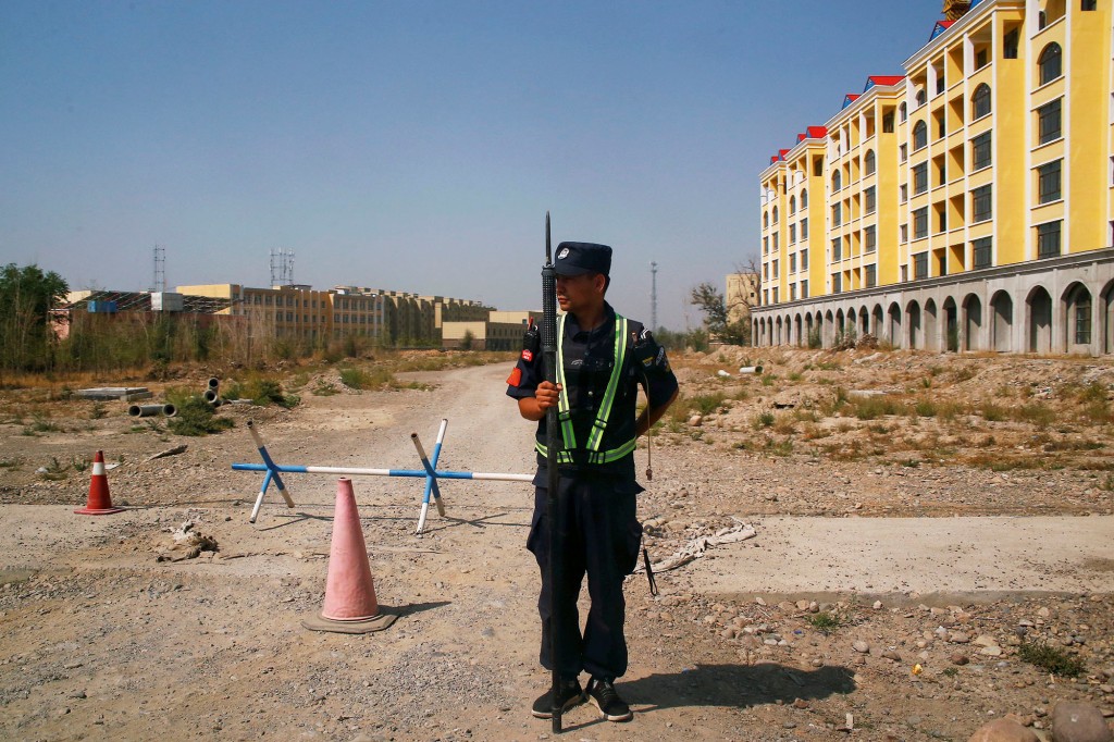 Un oficial de policía chino toma su posición junto a la carretera cerca de lo que oficialmente se llama un centro de educación vocacional en Yining.