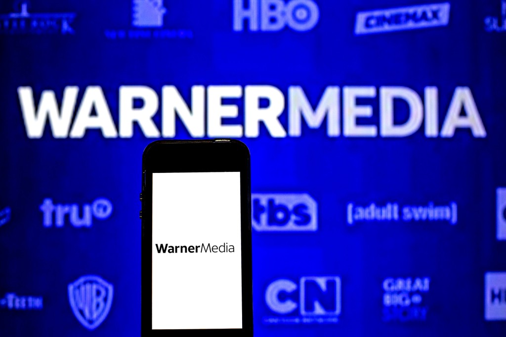 En esta ilustración fotográfica, se ve el logotipo de WarnerMedia en un teléfono inteligente y en el fondo.