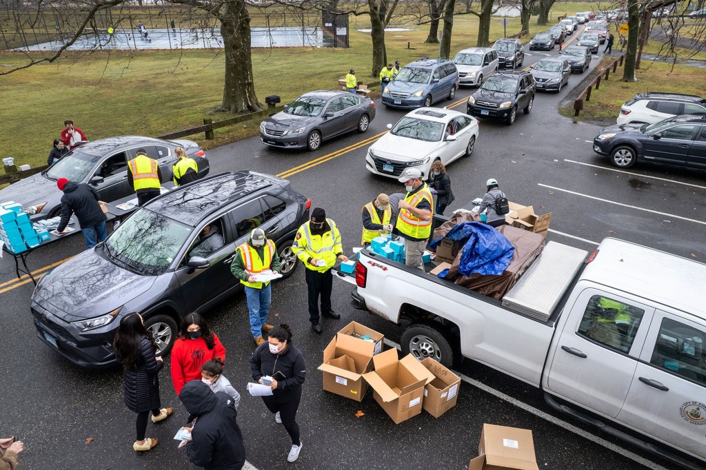 Las personas reciben kits de prueba de COVID-19 gratuitos en el hogar en un sitio de distribución el 2 de enero de 2022 en Stamford, Connecticut.