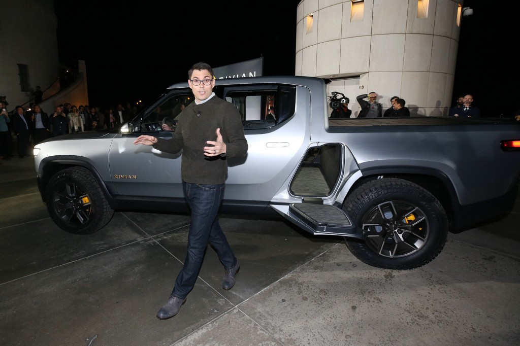 El CEO de Rivian, RJ Scaringe, hablando frente a un camión Rivian detrás de él