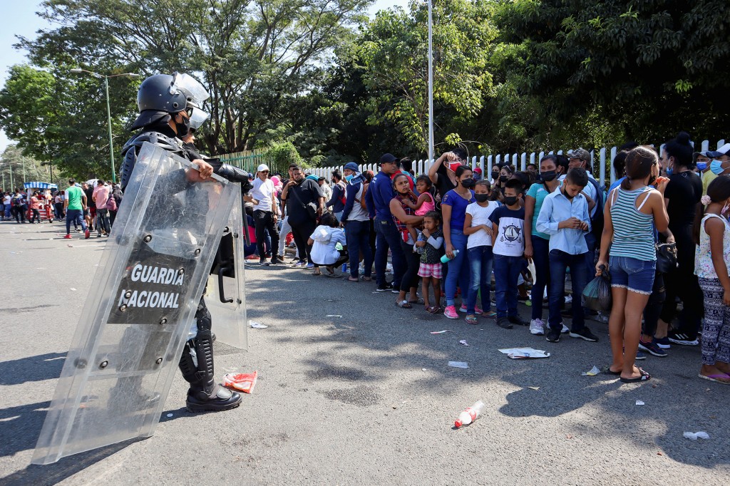 Migrantes de Centroamérica hacen fila mientras esperan un código QR para registrar su situación migratoria, en Tapachula, en el estado de Chiapas, México, 29 de diciembre de 2021