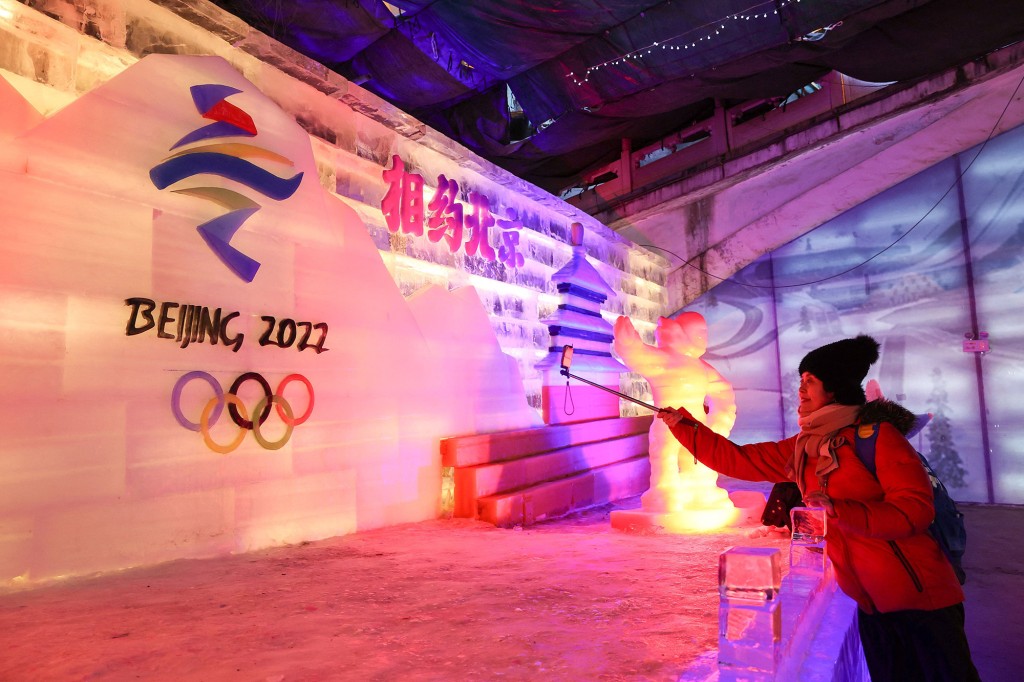 Un visitante tomando fotos de una escultura de hielo para los Juegos Olímpicos y Paralímpicos de Invierno de Beijing 2022 en Beijing.