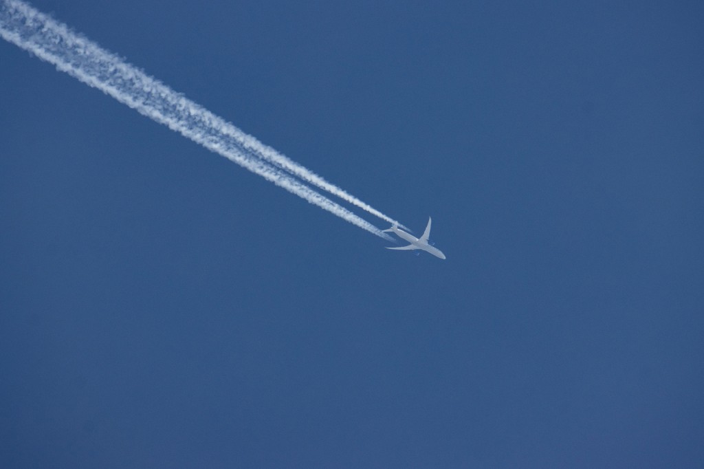 Un avión Boeing 787 Dreamliner de United Airlines sobrevuela el cielo azul de Ámsterdam.