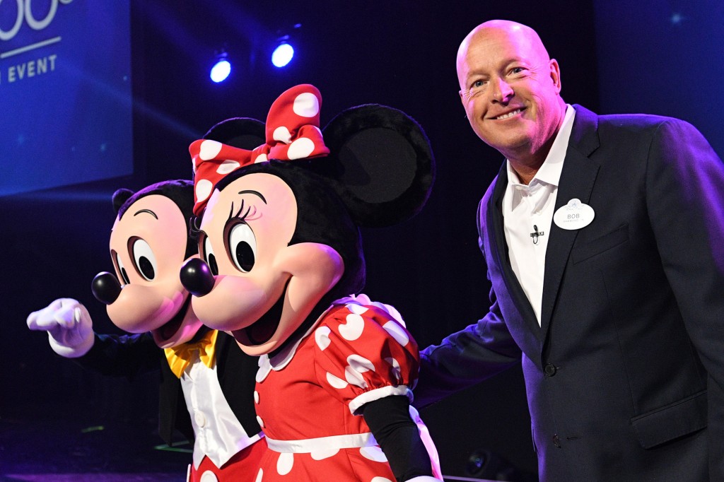 Bob Chapek sonriendo junto a personajes disfrazados de Mickey y Minnie Mouse