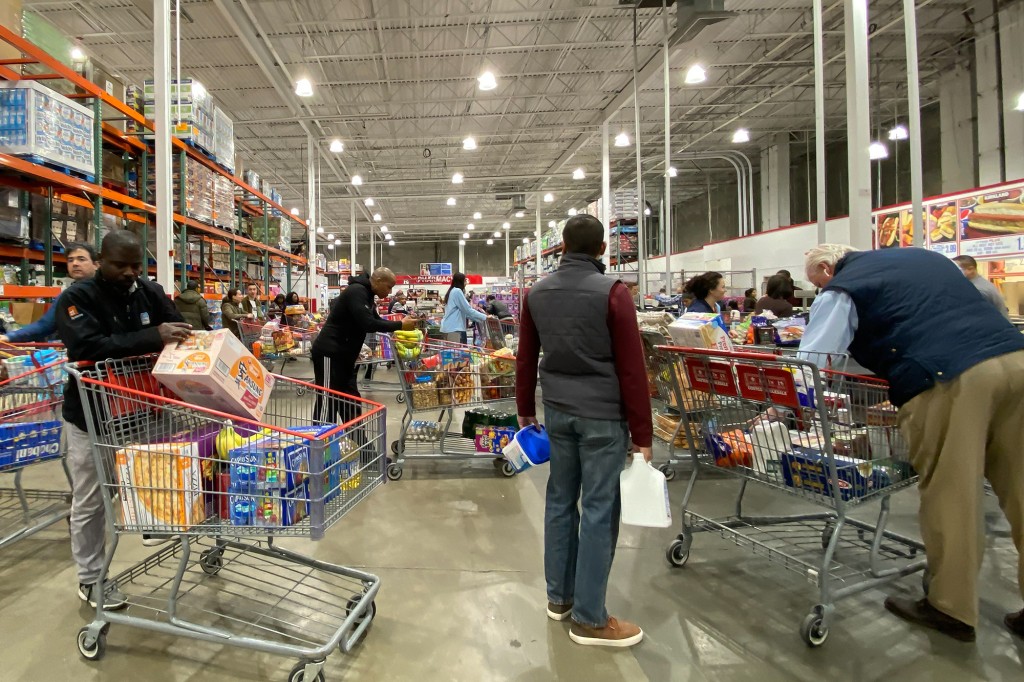 Personas que usan carritos de compras grandes en una tienda de alimentos