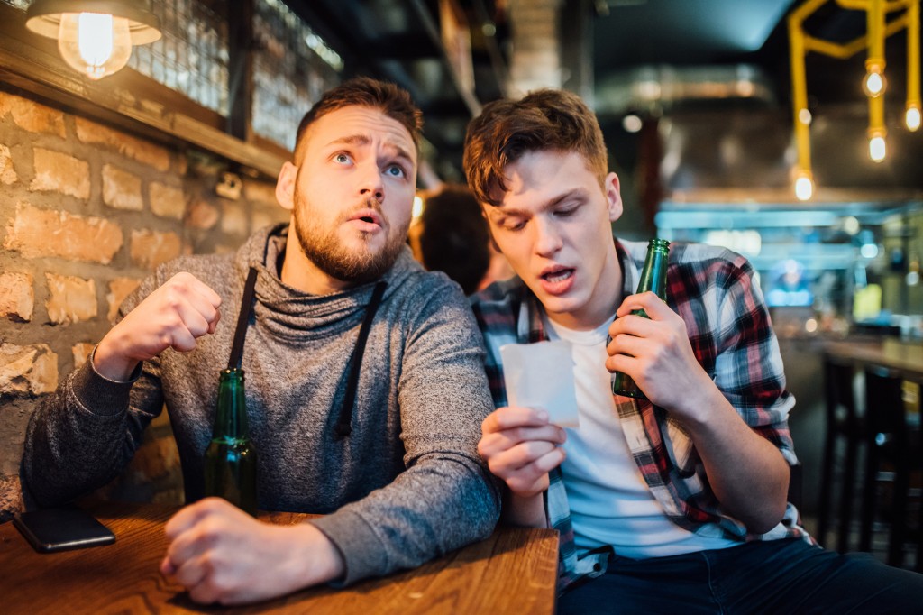 Jóvenes bebiendo cerveza y apostando en el pub