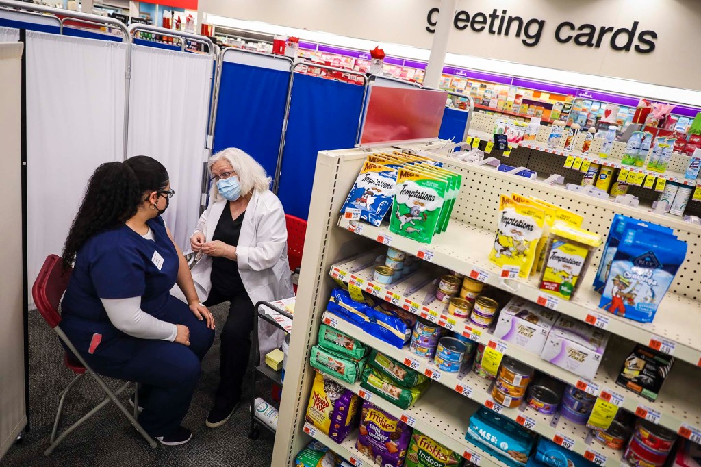 Un técnico de farmacia de CVS (izquierda) habla con una enfermera después de recibir la vacuna contra el COVID-19 en un CVS.