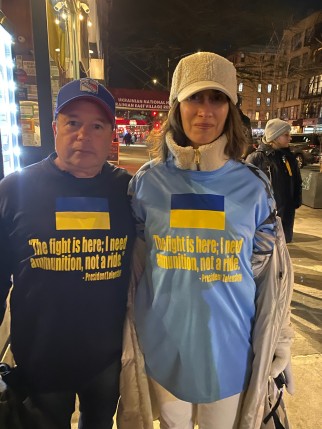 Un hombre y una mujer vestidos de amarillo y azul se paran frente a Veselka.