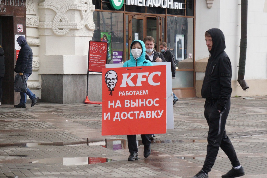 Una persona con un cartel de sándwich que anuncia KFC en Rusia.