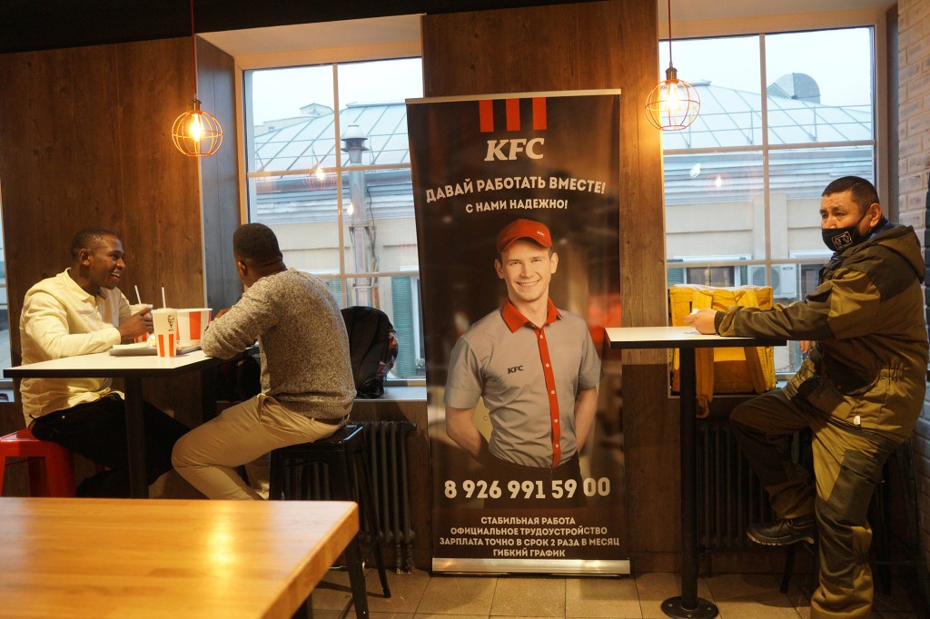 Un restaurante de KFC en Rusia que muestra un anuncio con un empleado con un uniforme de KFC.