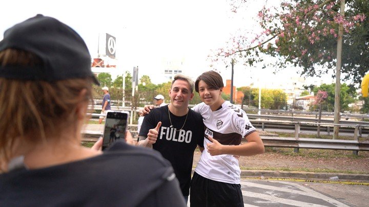 Una madre le toma una foto a su hijo con Momo en la cancha Platense.